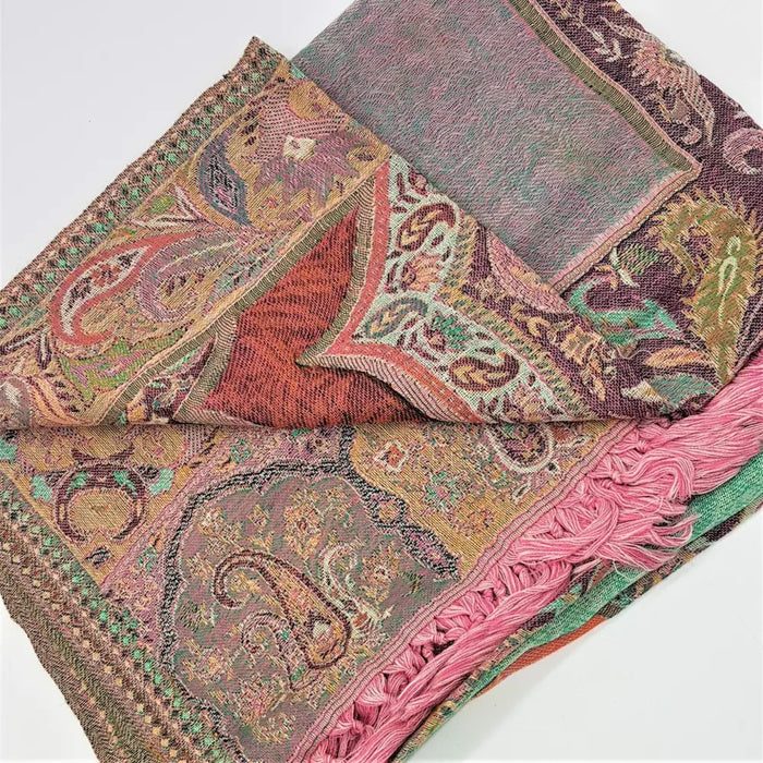 A soft pashmina shawl with a woven paisley pattern in muted earth tones and vibrant pink fringe