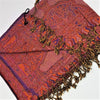 A richly patterned red and purple pashmina scarf with paisley design and fringed edges in fine woven fabric
