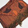 A richly textured orange and black paisley pashmina shawl with intricate woven designs and fringed edges