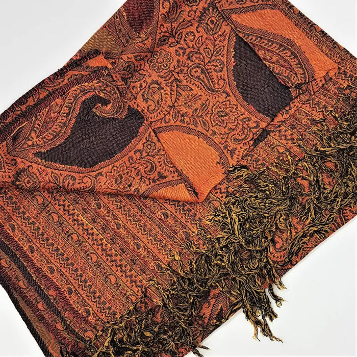 A richly textured orange and black paisley pashmina shawl with intricate woven designs and fringed edges