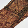 A richly textured brown and gold paisley patterned pashmina scarf with fringed edges in fine woven fabric