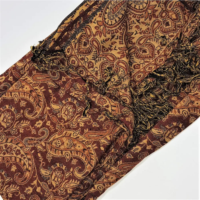 A richly textured brown and gold paisley patterned pashmina scarf with fringed edges in fine woven fabric