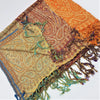 A fine woven pashmina shawl in orange brown and teal with multi toned paisley design and fringed edges