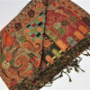 A richly patterned orange and green pashmina scarf with floral paisley and geometric designs and fringed edges