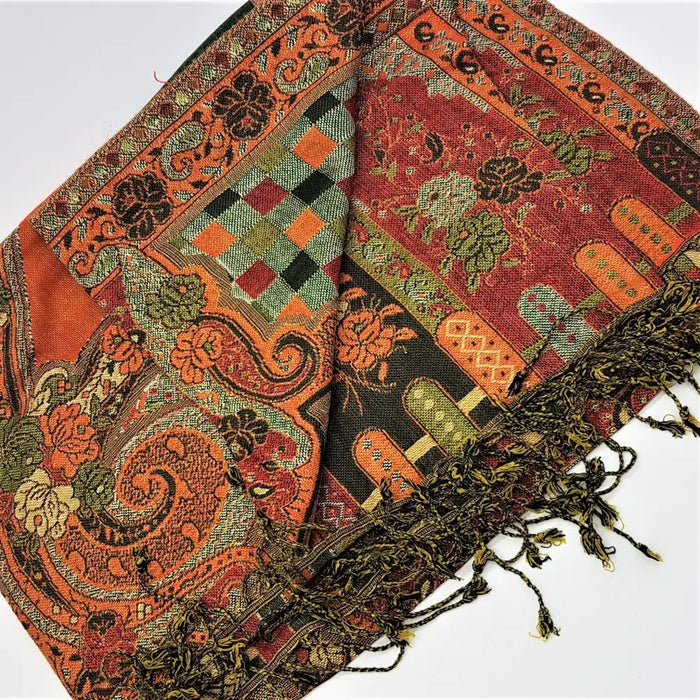 A richly patterned orange and green pashmina scarf with floral paisley and geometric designs and fringed edges