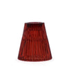 A translucent amber glass flip dinner candle holder with vertical ridges and flared base for candles