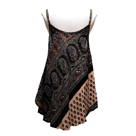 A black and beige sleeveless dress with indian print, green spaghetti straps, and a flowing asymmetrical hemline