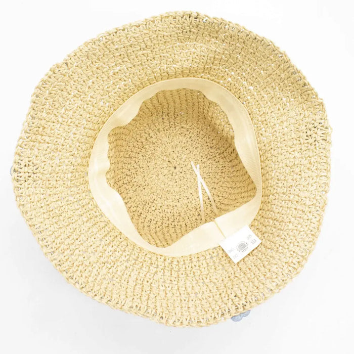 Beige floppy straw sun hat with woven texture and soft flexible inner band featuring blue flower details