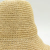 Beige floppy straw sun hat with tightly knitted texture and slightly flared brim made from woven straw material
