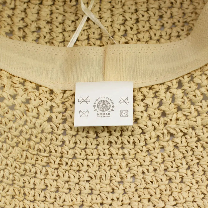 Beige floppy straw sun hat with woven straw material and soft breathable fabric band with branded label