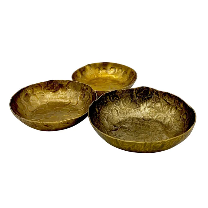Set of three hammered brass bowls with forged antique finished textured bubble surface in warm golden color