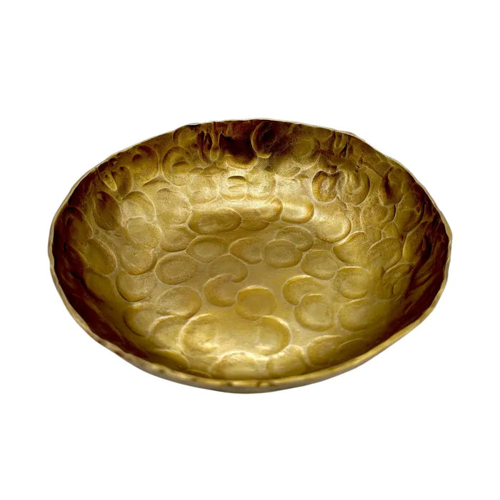 A golden hammered metal bowl with a textured circular pattern in a forged antique finished style