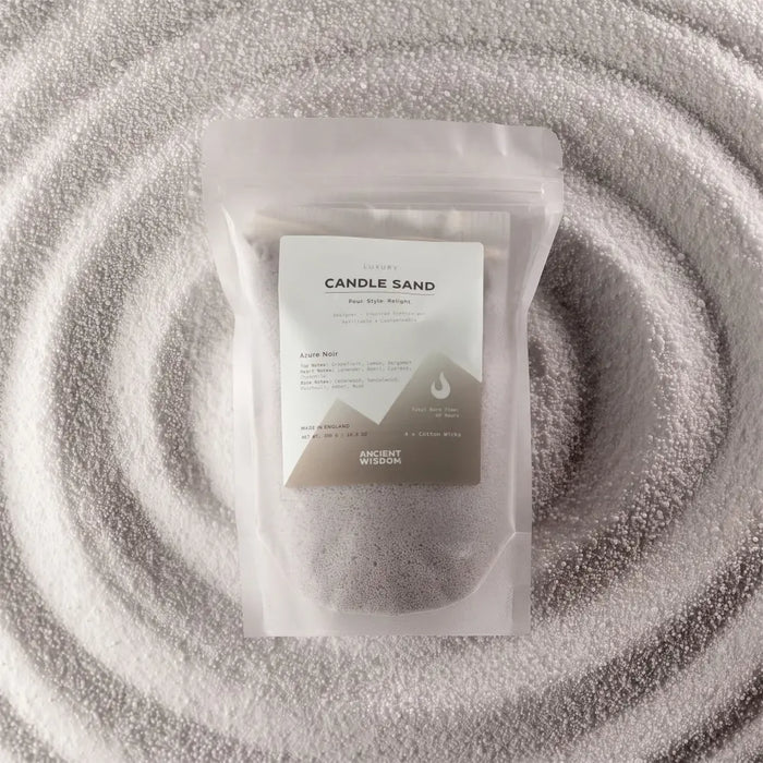 A clear pouch of luxury dark gray candle sand by ancient wisdom fragranced with azure noir woody finish 300g