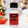 A clear glass bottle with black cap and red star label contains 10ml frankincense fragrance oil with allergen declarations