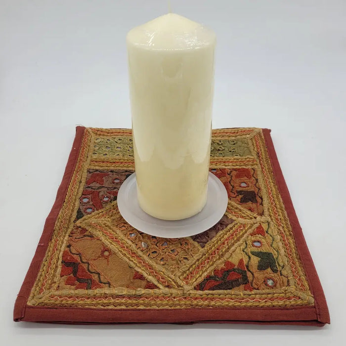 Cream-colored pillar candle with smooth glossy surface on a frosted glass pillar candle stand for christmas pillar candles
