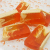 Vibrant orange and cream fruity handmade soap slice with honeycomb pattern and gel like translucent texture