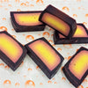 Rectangular fruity handmade soap slices with dark outer layer and yellow to orange gradient inner core in various fragrances