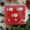 Red rectangular handmade soap with ho ho ho and star designs in white wrapped in clear plastic for christmas themes