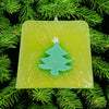 Funky handmade soap slice with lime green square shape and teal christmas tree in translucent wax with christmas themes