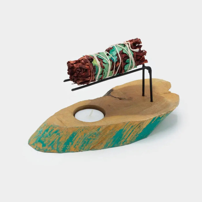 A gamal wood palo santo heater in teal and natural wood with a tea light holder and black metal sage stand