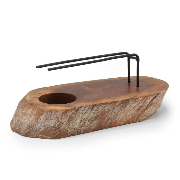 Rustic whitewash gamal wood palo santo heater with circular hole and black metal wire rack on a wooden cutting board