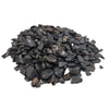 A pile of smooth black tourmaline gemstone chips in dark gray to black with rounded edges and polished finish