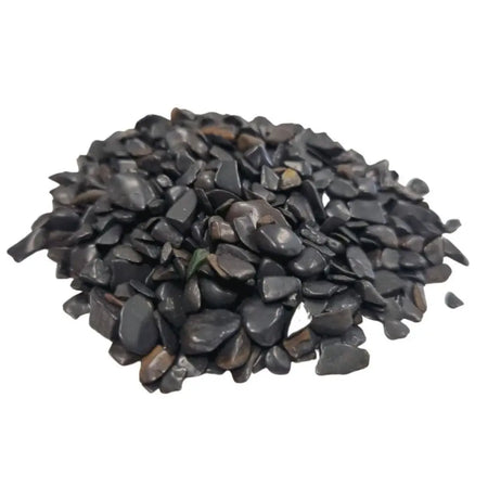 A pile of smooth black tourmaline gemstone chips in dark gray to black with rounded edges and polished finish