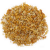 A pile of golden quartz chips in golden and beige tones with a smooth polished texture for gemstone use