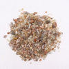 A pile of multicolored translucent moonstone gemstone chips in earthy tones weighing one kilogram