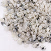 White and black speckled quartz gemstone chips in a 1kg bag labeled rainbow moon gemstone chips
