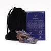 A polished sodalite dragon head figurine with blue and brown stone displayed next to its informational card