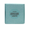 A light blue rectangular box with a white floral pattern labeled celestite gemstone enchantment lights in dark gray text