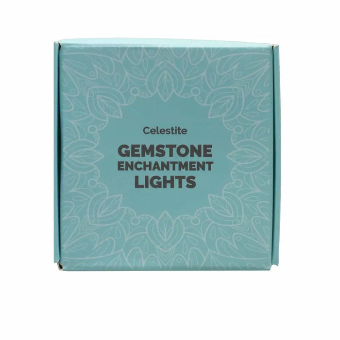 A light blue rectangular box with a white floral pattern labeled celestite gemstone enchantment lights in dark gray text