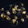 String of warm-toned translucent amber glass rock-shaped enchantment lights called gemstone enchantment lights citrine