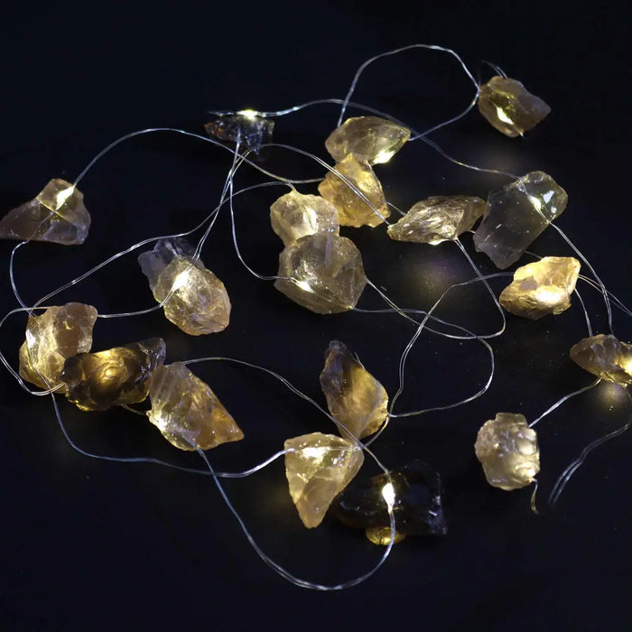 String of warm-toned translucent amber glass rock-shaped enchantment lights called gemstone enchantment lights citrine