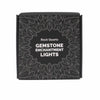 Black rectangular box with silver leaf design and white text showing rock quartz gemstone enchantment lights product name