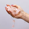 A delicate string of pink rose quartz beads in the gemstone enchantment lights with translucent irregular shapes