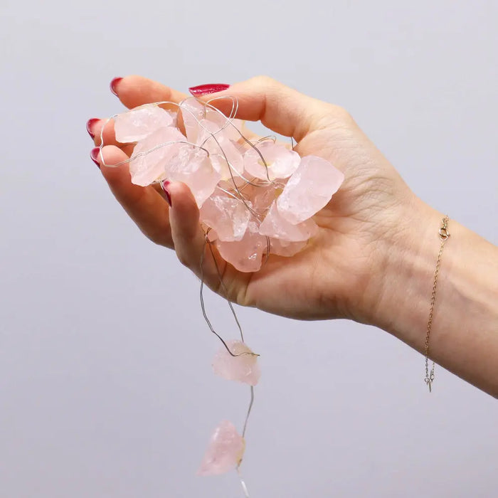 A delicate string of pink rose quartz beads in the gemstone enchantment lights with translucent irregular shapes