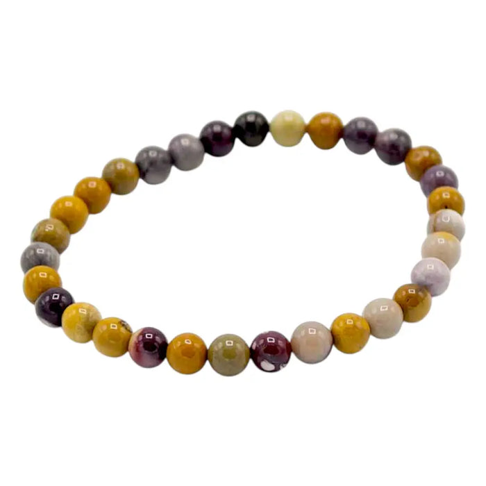 A colorful stretchy gemstone manifestation bracelet with rare mookiate beads in yellow purple gray and cream tones