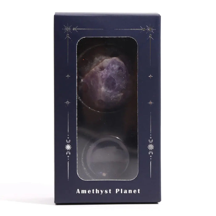 A polished deep purple amethyst gemstone planet charm with a faceted surface on a solar stand