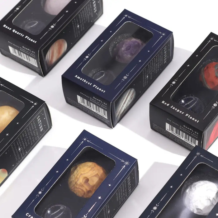 Dark blue boxes with clear windows holding spherical gemstones labeled amethyst planet and crazy lace jasper mercury planet