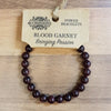 A dark red blood garnet gemstone bead bracelet with a simple design and no visible metal clasps for mood balance