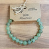A gemstone power bracelet made of light green jade stone beads with subtle dark inclusions for mood balance