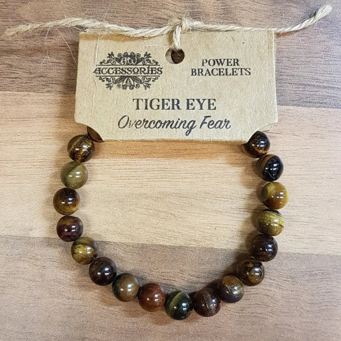 A tiger eye gemstone bracelet with polished round beads showing golden brown and dark brown stripes for mood balance