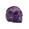 A polished purple amethyst gemstone skull carving with intricate details and a glossy finish