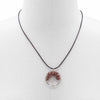 A circular gemstone tree of life pendant with red jasper stones set in a silver-toned frame on a black cord