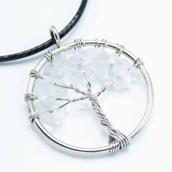 Silver wire-wrapped gemstone tree of life pendant with clear rock crystal in circular frame on black cord