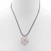 A gemstone tree of life pendant with a translucent pink rose quartz stone and silver wire design on a black cord