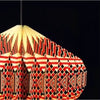 A geometric patterned origami paper pendant lamp with bold red black and cream triangular and diamond motifs