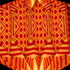 A geometric origami paper lantern light shade with red and orange diamond and striped patterns in bright colors